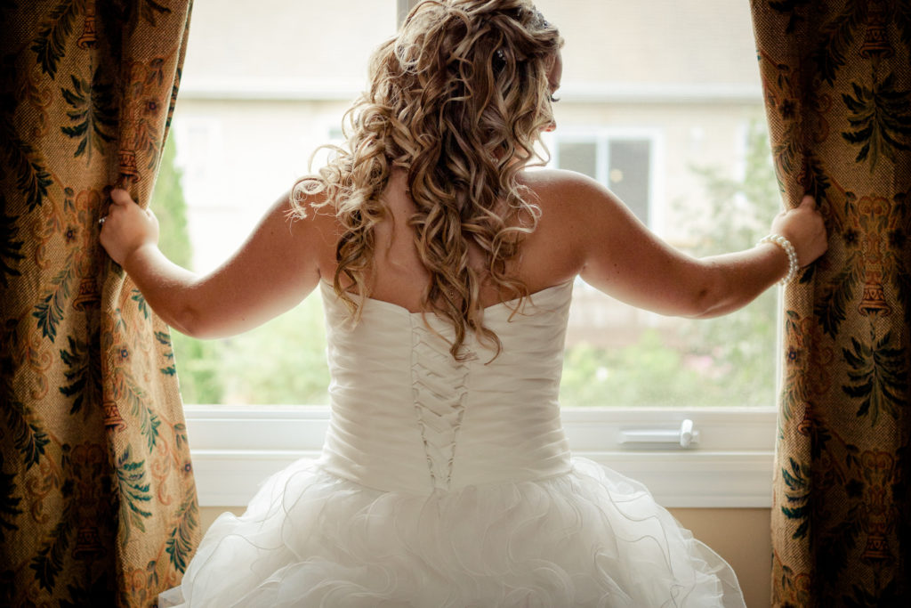 Bride standing at the window looking out