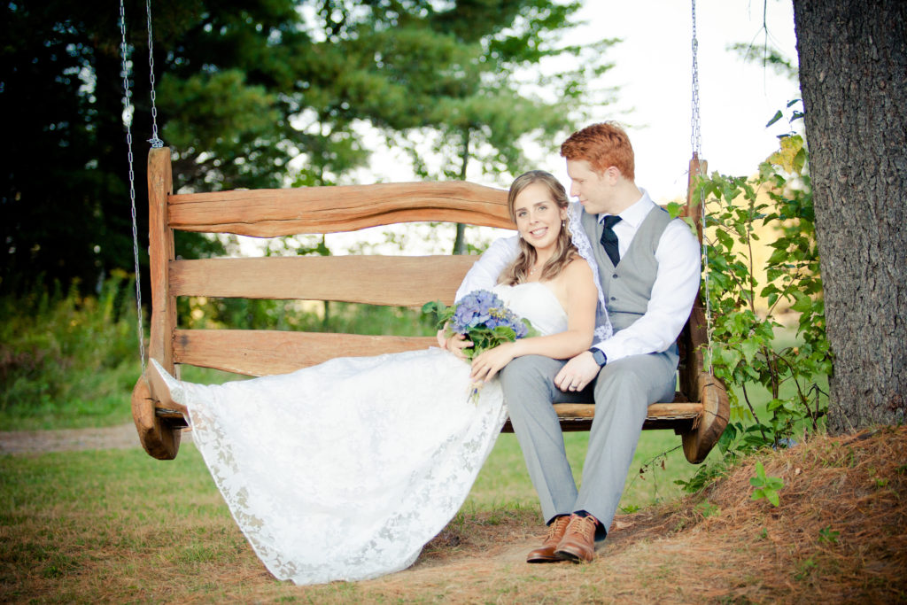 Bride and groom on a wooden swing at Beantown Receptions