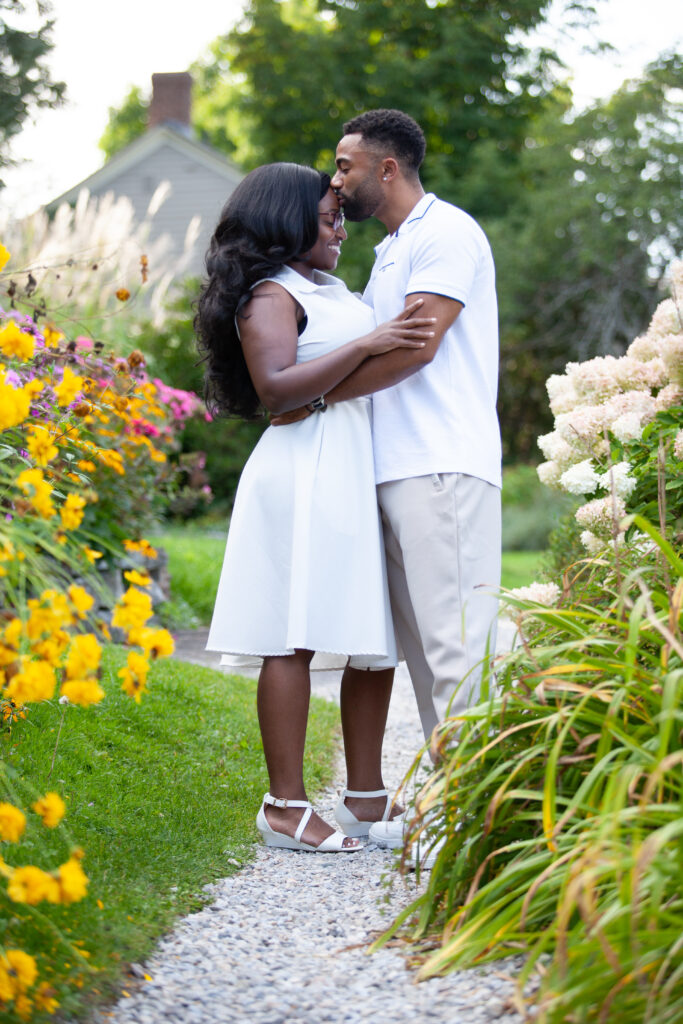 Happy couple embracing during summer engagement shoot surrounded by flowers in Ottawa